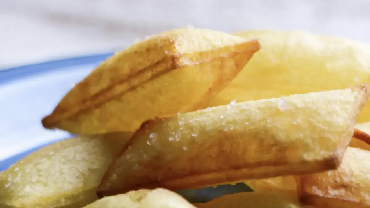 Patatas soufflé doradas y crujientes, espolvoreadas con sal gruesa, listas para disfrutar.