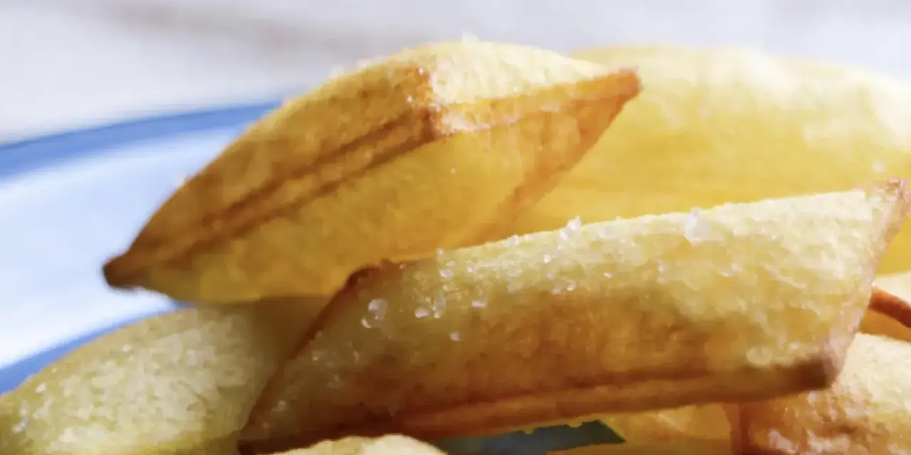 Patatas soufflé doradas y crujientes, espolvoreadas con sal gruesa, listas para disfrutar.