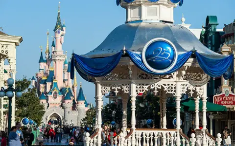 El castillo rosa de Disneyland Paris se alza majestuoso, con un quiosco decorado para celebrar el 25 aniversario.