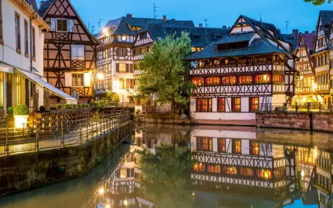 Casas con entramado de madera reflejadas en un canal, un ejemplo de la calidad de vida en Francia.