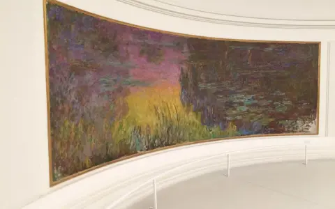 Un estanque de nenúfares con reflejos vibrantes de atardecer, una obra maestra impresionista en el **museo de la Orangerie**.