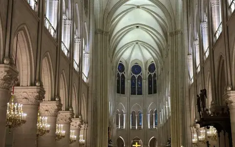 Interior de Notre Dame, con sus impresionantes arcos góticos, vitrales y candelabros dorados. Las **entradas Notre Dame** se abren a este majestuoso espacio.