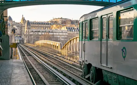 Un tren del metro de París, Francia, avanza por las vías al atardecer.