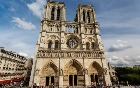 La fachada de Notre Dame, con sus torres gemelas y rosetón, se alza majestuosa. Hoy se puede visitar Notre Dame, un icono de París lleno de historia.