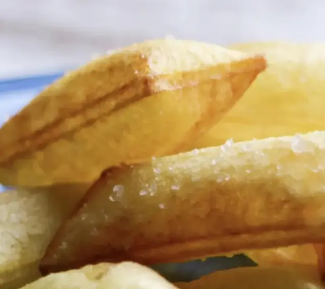 Patatas soufflé doradas y crujientes, espolvoreadas con sal gruesa, listas para disfrutar.