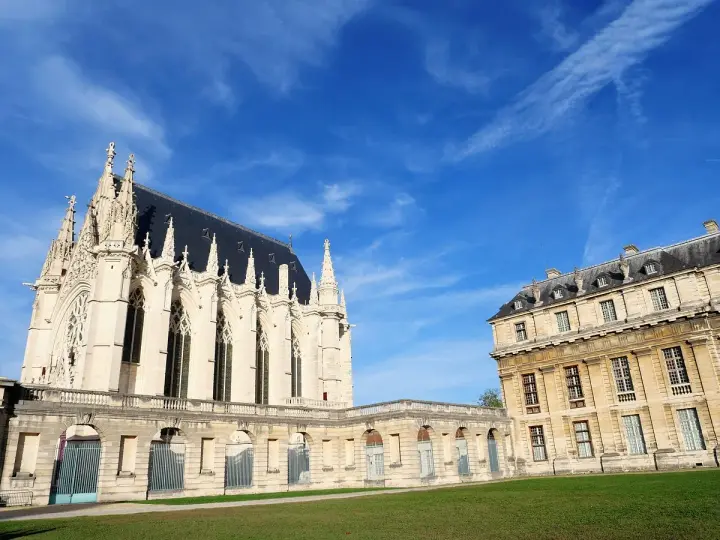 El castillo de Vincennes, con su imponente arquitectura gótica y clásica, se alza bajo un cielo azul vibrante.