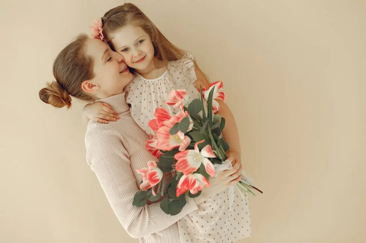 Una madre y su hija se abrazan con un ramo de tulipanes, un tierno regalo para el día de la madre en Francia.