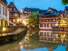 Casas con entramado de madera reflejadas en un canal, un ejemplo de la calidad de vida en Francia.