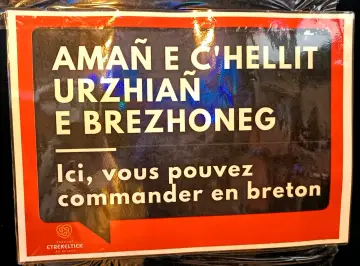 Cartel en bretón y francés: "Aquí puedes pedir en bretón". Un festival en Bretaña, Francia.