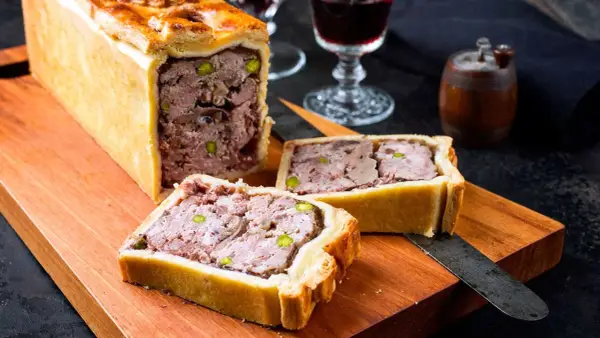 Deliciosa pate en croute receta, un pastel de carne jugoso y sabroso, listo para ser cortado y disfrutado.